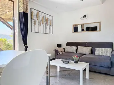 a living room with a couch and a table at Mini Villa Santa Giulia double vue mer à 5 min de la plage à pied in Porto-Vecchio