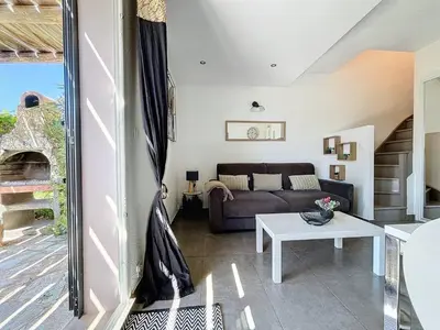 a living room with a couch and a table at Mini Villa Santa Giulia double vue mer à 5 min de la plage à pied in Porto-Vecchio