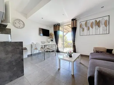 a living room with a couch and a table at Mini Villa Santa Giulia double vue mer à 5 min de la plage à pied in Porto-Vecchio