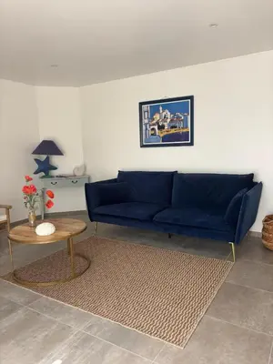 a living room with a blue couch and a table at Casa Orizonte, Viggianello in Viggianello
