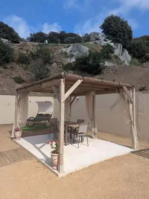 a wooden gazebo with a table and chairs at Casa Orizonte, Viggianello in Viggianello