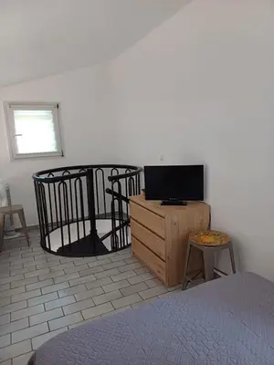 a bedroom with a bed and a tv on a wooden cabinet at Porto Vecchio - Résidence RIVIERA - Villa St Cyprien in Lecci