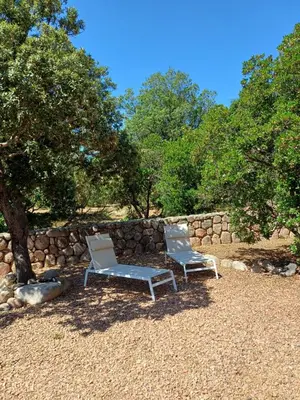 a table and a chair in front of a house at Porto Vecchio - Résidence RIVIERA - Villa St Cyprien in Lecci