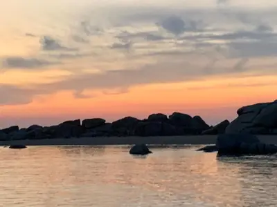 a group of rocks in the water at sunset at Appartement 2 chambres 2 salles de bains haute ville in Porto-Vecchio