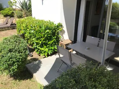 a table and chairs on the porch of a house at Studio avec jardin Route des sanguinaires Barbicaja in Ajaccio