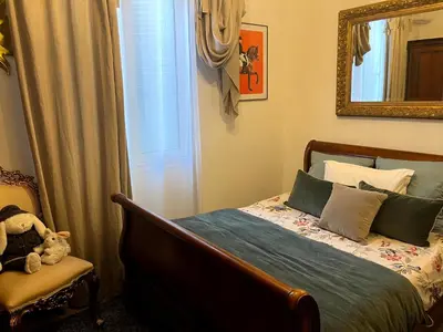 a bedroom with a bed and a chair and a mirror at Appartement T3 centre ville in Ajaccio