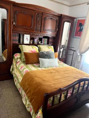 a bedroom with a large bed with a wooden headboard at Appartement T3 centre ville in Ajaccio