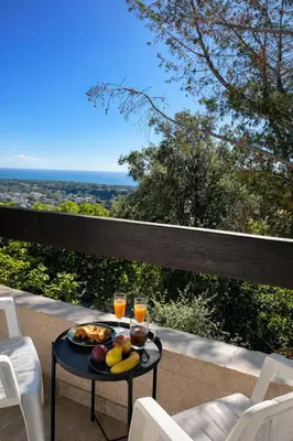 a table with a plate of fruit and two glasses of orange juice at Maison avec vue mer in Penta-di-Casinca