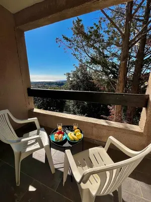 a balcony with two chairs and a table with fruit on it at Maison avec vue mer in Penta-di-Casinca