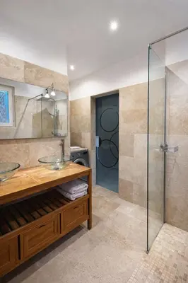 a bathroom with two sinks and a glass shower at Maison avec vue mer in Penta-di-Casinca
