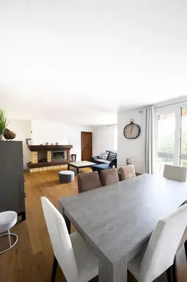 a dining room and living room with a table and chairs at Maison avec vue mer in Penta-di-Casinca