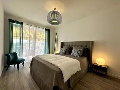 a bedroom with a bed and a chair and a lamp at Magnifique appartement 3 pièces avec double vue mer in Ajaccio