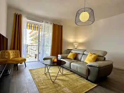 a living room with a couch and a table at Magnifique appartement 3 pièces avec double vue mer in Ajaccio