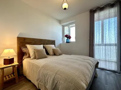 a bedroom with a large bed and a window at Magnifique appartement 3 pièces avec double vue mer in Ajaccio