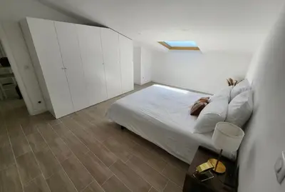 a white bedroom with a bed and white cabinets at T2 Sanguinaires - 150m de la mer in Ajaccio