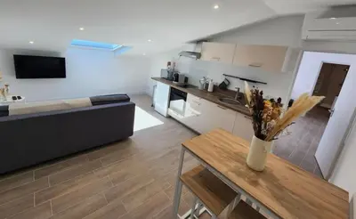 a living room with a couch and a table and a kitchen at T2 Sanguinaires - 150m de la mer in Ajaccio