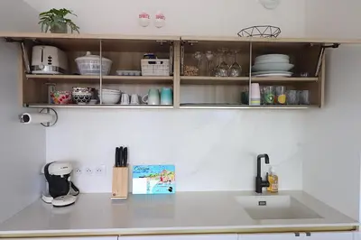 a kitchen with a white counter top and a sink at T3 Le Bohème au Villas Acum - Domaine de Standing avec Vue Mer & Excellente situation géographique in Grosseto-Prugna