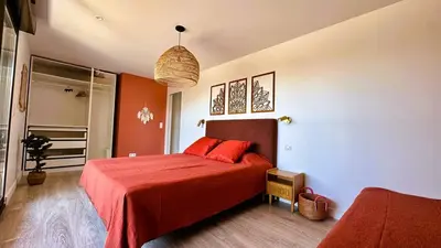 a bedroom with a red bed with two red pillows at Villa Dalenassara, 14 pers, piscine chauffée, 2 min plage en voiture in Olmucciu