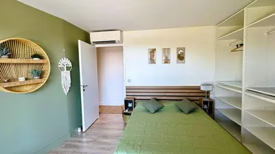 a bedroom with a green bed in a room at Villa Dalenassara, 14 pers, piscine chauffée, 2 min plage en voiture in Olmucciu