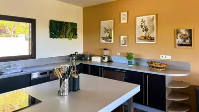 a kitchen with a table and a counter top at Villa Dalenassara, 14 pers, piscine chauffée, 2 min plage en voiture in Olmucciu