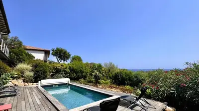 a swimming pool sitting on top of a wooden deck at Villa Dalenassara, 14 pers, piscine chauffée, 2 min plage en voiture in Olmucciu