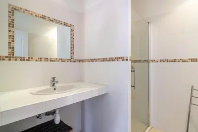 a white bathroom with a sink and a mirror at monte barbatu in Propriano