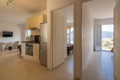 a kitchen with a door open to a living room at monte barbatu in Propriano