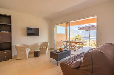 a living room with a couch and a table with an umbrella at monte barbatu in Propriano