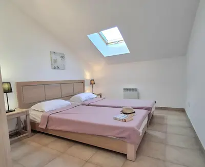 a bedroom with a bed and a skylight at Villas MELODY - Appartement climatisé 4/6 pers in Santa-Maria-Poggio