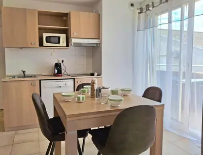 a kitchen with a wooden table and chairs in a room at Villas MELODY - Appartement climatisé 4/6 pers in Santa-Maria-Poggio
