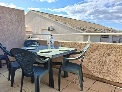 a table and chairs sitting on a balcony at Villas MELODY - Appartement climatisé 4/6 pers in Santa-Maria-Poggio