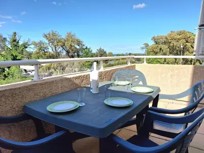 a blue table with two chairs and a bottle of wine at Villas MELODY - Appartement climatisé 4/6 pers in Santa-Maria-Poggio