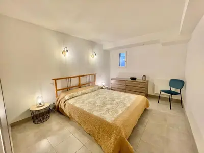 a bedroom with a bed and a desk and a chair at Appartement avec piscine 8 personnes in Porto-Vecchio