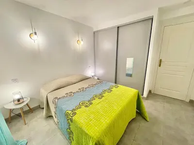 a bedroom with a bed with a yellow blanket at Appartement avec piscine 8 personnes in Porto-Vecchio