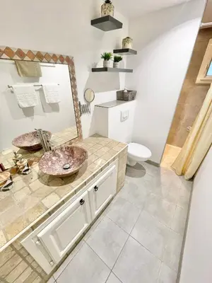 a bathroom with a sink and a mirror at Appartement avec piscine 8 personnes in Porto-Vecchio