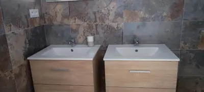 a bathroom with a white sink and wooden cabinets at Fior di Lucia in Zonza