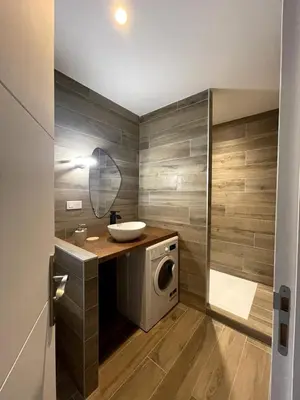 a bathroom with a washing machine and a sink at Appartement Terrasse in Porto-Vecchio