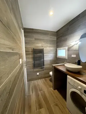 a bathroom with a sink and a washing machine at Appartement Terrasse in Porto-Vecchio