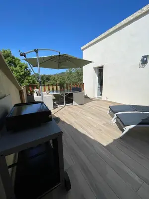a patio with a table and an umbrella at Appartement Terrasse in Porto-Vecchio