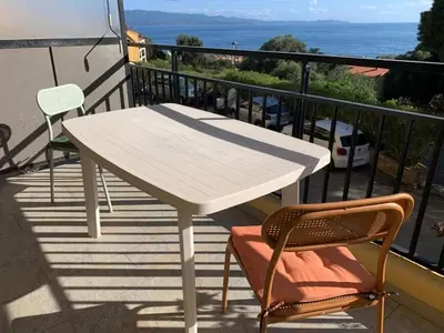 a white table and two chairs on a balcony at Coin de paradis aux Sanguinaires in Ajaccio