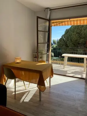 a living room with a table on a patio at Coin de paradis aux Sanguinaires in Ajaccio