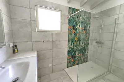 a bathroom with a shower and a sink and a window at Ecological house with solar electricity in Ajaccio