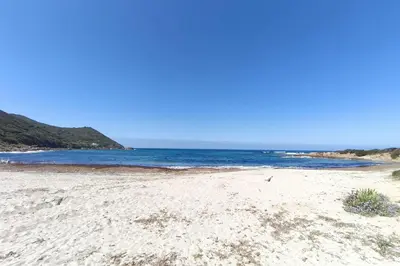 a sandy beach with the ocean in the background at Ecological house with solar electricity in Ajaccio