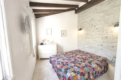 a bedroom with a bed and a brick wall at Ecological house with solar electricity in Ajaccio