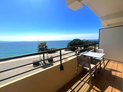 a balcony with a table and a view of the ocean at L'AZUR des calanques - T2 avec Piscine Chauffée & Vue Mer Exceptionnelle- Parking & Wifi in Ajaccio