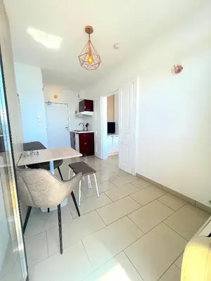 a kitchen and dining room with a table and chairs at L'AZUR des calanques - T2 avec Piscine Chauffée & Vue Mer Exceptionnelle- Parking & Wifi in Ajaccio
