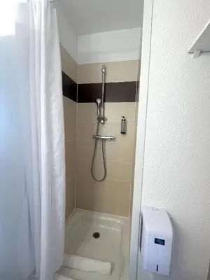 a bathroom with a shower with a shower curtain at L'AZUR des calanques - T2 avec Piscine Chauffée & Vue Mer Exceptionnelle- Parking & Wifi in Ajaccio