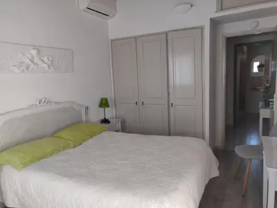 a white bedroom with a white bed and a table at Domaine De Foresta in Bonifacio