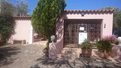 a white house with a door with potted plants at Domaine De Foresta in Bonifacio