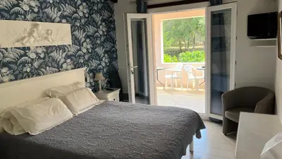 a bedroom with a bed and a sliding glass door at Domaine De Foresta in Bonifacio